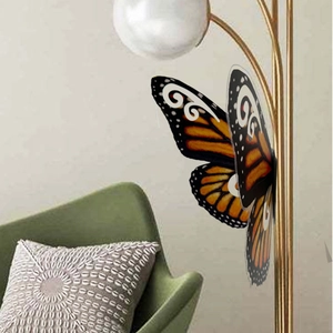 Detalle de pegatina de pared de mariposa 3D monarca fijada a una lámpara de metal