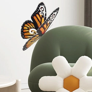 Detalle macro de un adhesivo de pared de mariposa 3D naranja con alas plegables