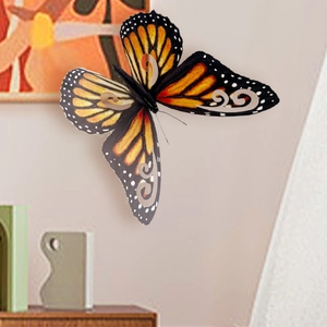 Detalle de pegatina de pared mariposa monarca 3D con patrones huecos naranjas