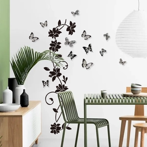 Detail of black butterfly and floral vine wall decals applied on a white living room wall