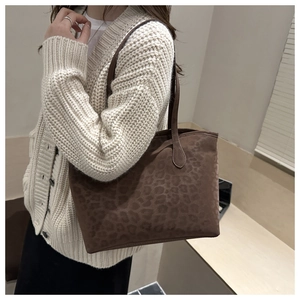 Detailed view of large brown leopard print tote bag worn on shoulder for style