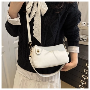 Close-up of white lychee pattern leather bag with gold hardware and fashion lettering