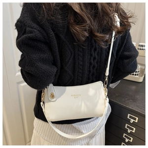 Close-up of white lychee textured crossbody bag with gold metal lock and fashion text