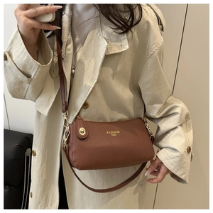 Detail of the brown lychee pattern leather crossbody bag with golden hardware and fashion text