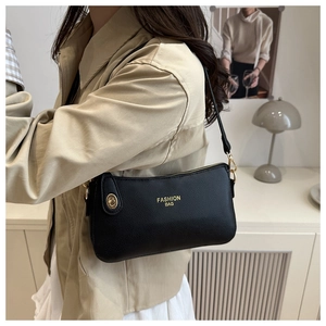 Close-up of black crescent bag with lychee texture and gold fashion lettering