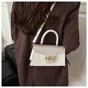 Detail der eleganten beigen Tasche mit Strickstruktur und goldener M-Metallschnalle