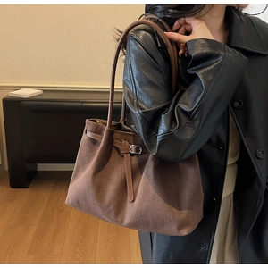 Side view of deep brown suede tote bag with leather straps and metallic buckle detail