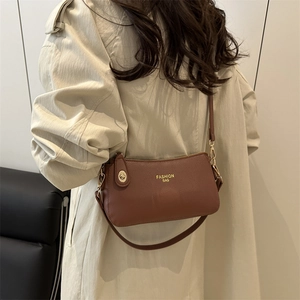 Brown textured leather crescent shoulder bag with metallic buckle for stylish daily commute