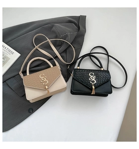 Macro view of chic crossbody bag featuring snakeskin texture and S-shaped gold buckle