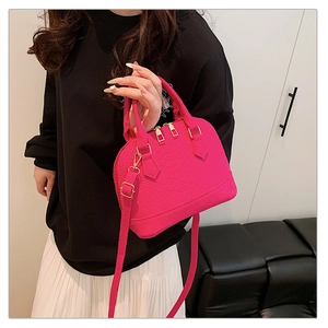 Macro detail of rose pink crocodile embossed leather bag with premium gold metal hardware