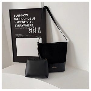 Detail der schwarzen großen Bucket Bag mit passender Tasche und goldener Logo-Prägung