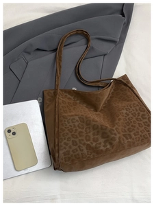 Macro detail of brown leopard print faux suede fabric texture on the large tote bag