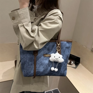 Large denim blue tote bag with brown leather straps and cute cloud plush charm
