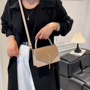 Petit sac carré beige tissé élégant avec pompon doré pour femme, porté épaule