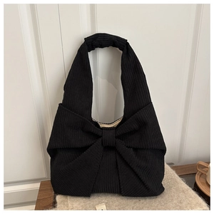 Détails de la texture du sac cabas en velours côtelé noir avec un grand nœud décoratif