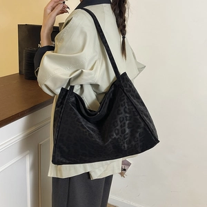 Chic black leopard print large tote bag for women worn by a model on shoulder