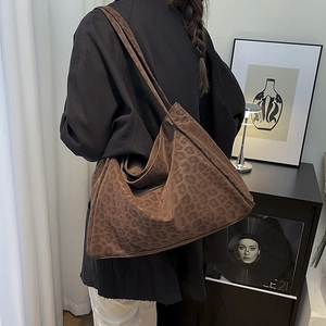 Chic leopard print hobo bag worn by a model in a cozy, stylish interior setting