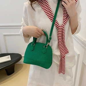 Green crocodile pattern shell handbag with top handle and adjustable shoulder strap