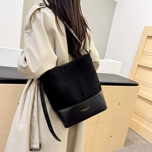 Schwarze Beuteltasche aus Wildleder und PU-Leder mit goldener Aufschrift an Modell in Beige