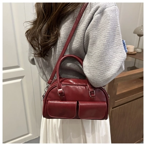 Side view of model wearing a vintage bordeaux red bowling bag with front pockets