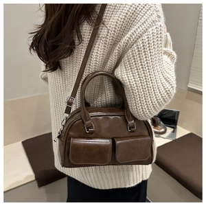 Detail of vintage brown Boston bag with double front pockets and silver-tone hardware