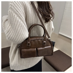 Detailed side view of vintage dark brown bowling bag with twin pockets and silver hardware