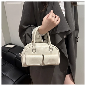 Close-up of cream PU leather bowling bag showing dual front flap pockets and texture