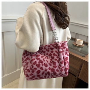 Sac fourre-tout en peluche léopard rose avec chaîne argentée porté par un modèle