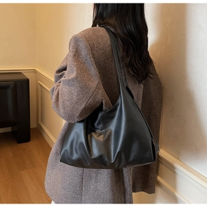 Detail of the soft leather texture and vertical stitching on this black large tote bag