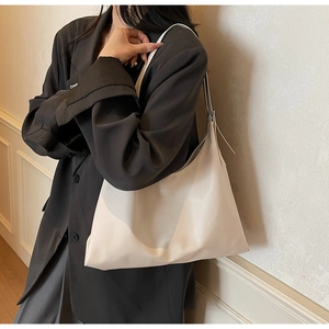 Detail shot of a large beige PU leather tote bag with soft texture and refined stitching