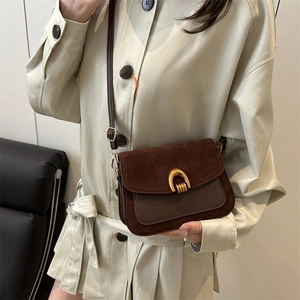 Retro dark brown underarm bag with gold horseshoe buckle shown on a model
