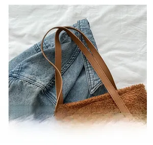 Detail of plush brown teddy tote bag with brown leather handles and fashion logo patch