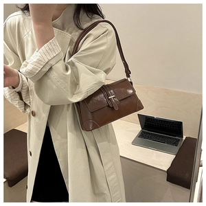 Détail du sac baguette vintage marron en cuir PU brillant avec fermoir métallique élégant