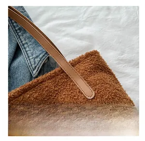 Detail of brown plush tote bag with soft teddy wool texture and leather handle
