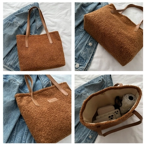 Detail view of brown plush tote bag with FASHION label, spacious interior and leather straps