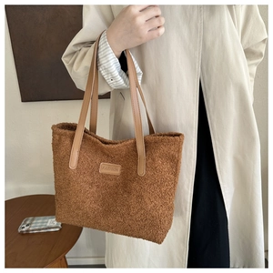 Detailed macro of brown plush tote bag with FASHION leather patch and tan handles