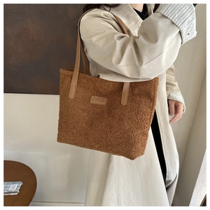 Detail view of brown faux fur tote bag with leather straps and Fashion label