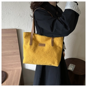 Detail of yellow fuzzy tote bag with leather FASHION patch and brown shoulder straps