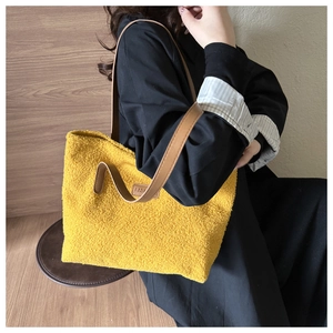 Detail of yellow fleece tote bag with brown leather strap and Fashion label