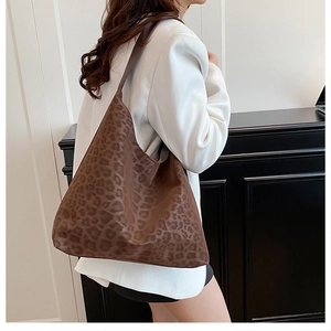 Side view of leopard print shoulder bag on model with minimalist white background