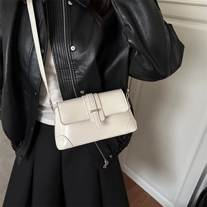 Sac baguette classique en cuir blanc porté par un mannequin au style vintage minimaliste