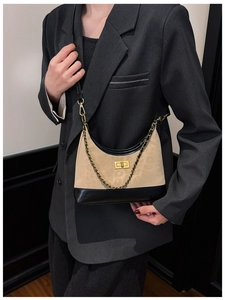 Detail der gesteppten Ledertasche mit Leopardenmuster und Goldverschluss am Blazer