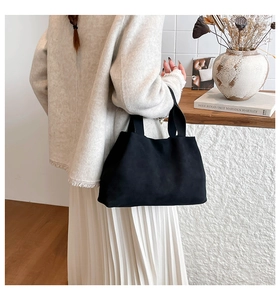 Minimalist black tote bag in suede texture styled in a warm home decor setting