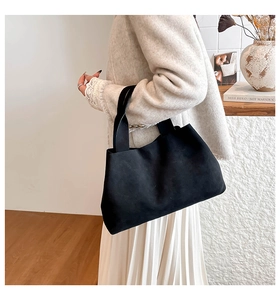 Minimalist black oversized tote bag made of matte suede material shown on model shoulder