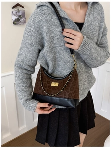Detail der modischen Schultertasche mit Leopardenmuster, goldenem Drehverschluss und Kette