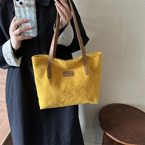 Yellow faux shearling tote bag with leather straps and central fashion patch detail