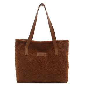Plush brown winter tote bag with faux leather straps and fashion label on front