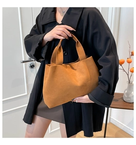 Detail of caramel suede leather tote bag with wide strap showing premium texture