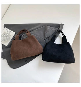 Detail of minimalist suede bucket bags in dark brown and black showing matte texture