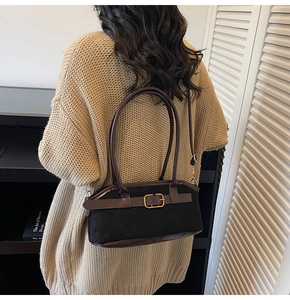 Retro black canvas tote bag with brown leather trim shown on a model's shoulder